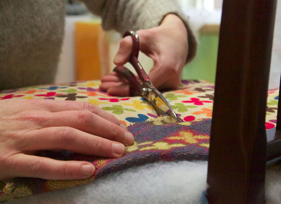 Heleen Nachtegaal bezig om een antieke stoel te stofferen met een moderne bekleding